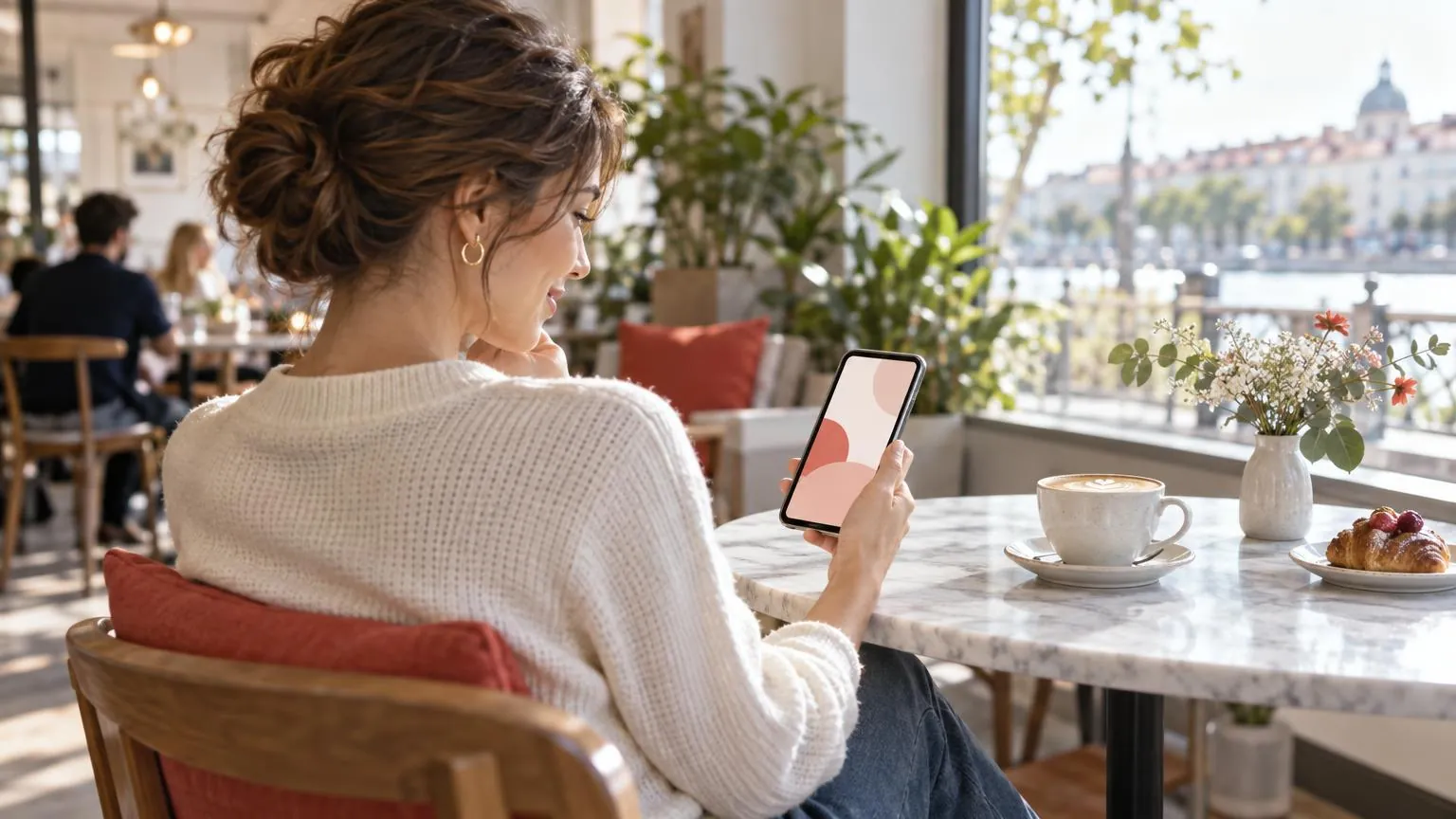Una donna in un bar che guarda un profilo social sul telefono